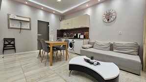 A modern living space with a dining area, kitchen, and sofa. - Quality&Design
Vitosha Blvd (Sofia)