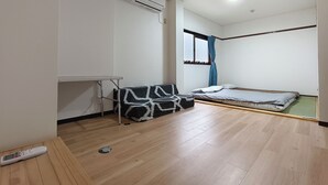 Ein Zimmer mit einem Bett, einem Schreibtisch und einem Heizkörper.