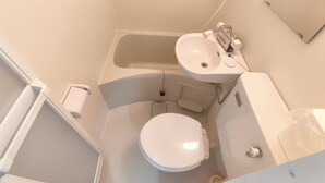 Ein kleines Badezimmer mit Toilette, Waschbecken und Badewanne.