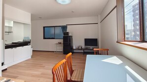 Eine moderne Küche mit Essbereich, einem Fernseher und einem Fenster mit Blick auf die Stadt.