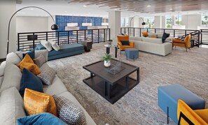 A spacious lounge area with multiple seating options, including sofas and chairs, a coffee table, and a railing overlooking a pool. - Modern Comfort & Style,  Apt with Balcony, Full Kitchen & Relaxing Stay. (Orlando)