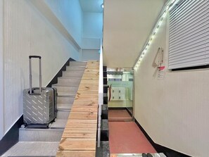 A hotel hallway with a wooden staircase, a suitcase, and a shoe rack. - 5 min to Subway/Airport BusPrivateRoom 20 min to Hongdae MyeongdongNearHan River (Seoul)