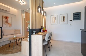 Eine moderne Küche mit einer Holzinsel, Pendelleuchten und einem Essbereich mit einer Couch und Sesseln.