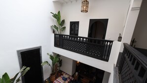 A multi-level interior with a balcony, potted plants, and a patterned floor. - New Luxurious Boutique Riad 4bdr Private house (Marrakech)