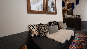 A modern living room with a black sofa, patterned cushions, and a colorful rug. - New Luxurious Boutique Riad 4bdr Private house (Marrakech)