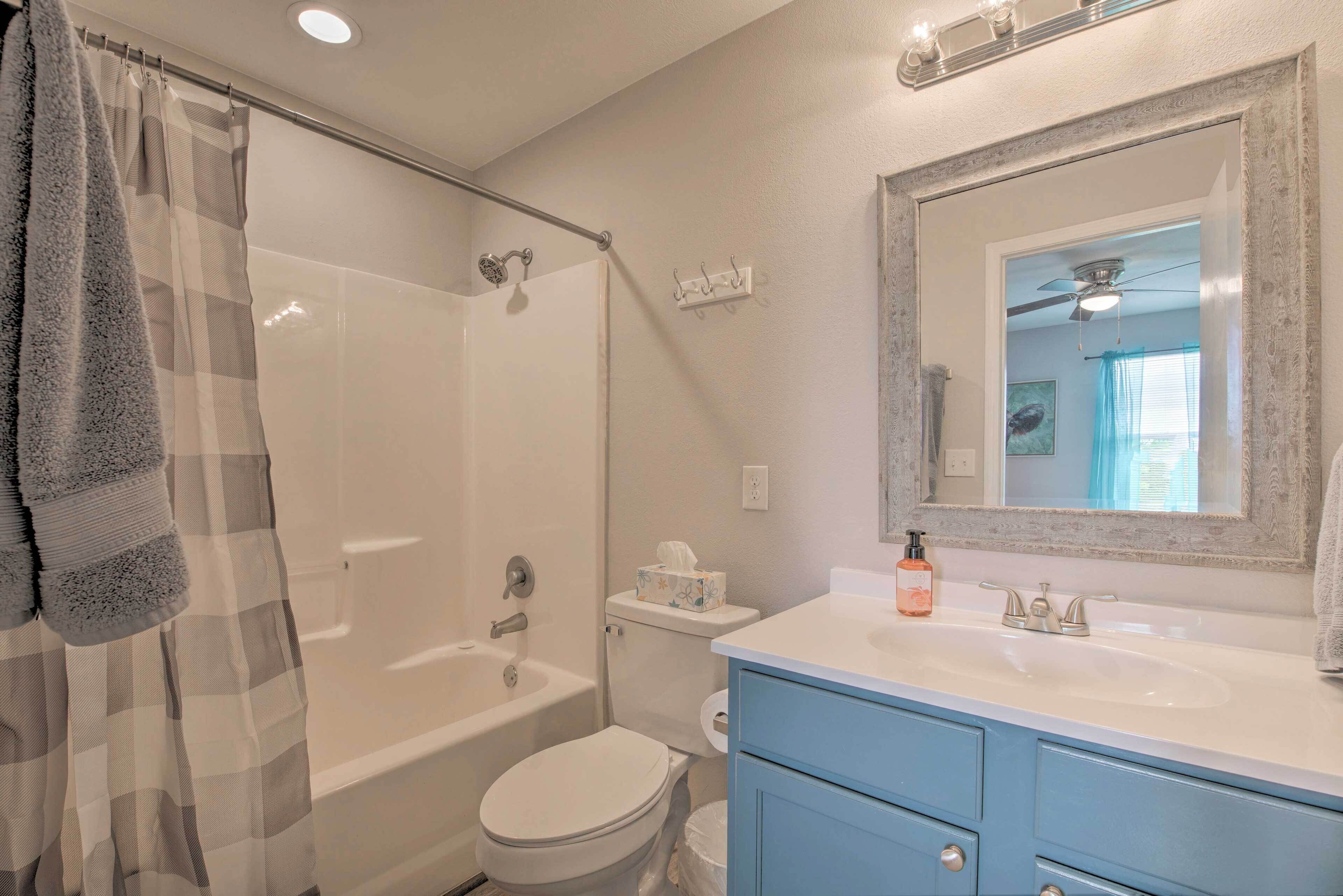 A bathroom with a shower, toilet, and sink.