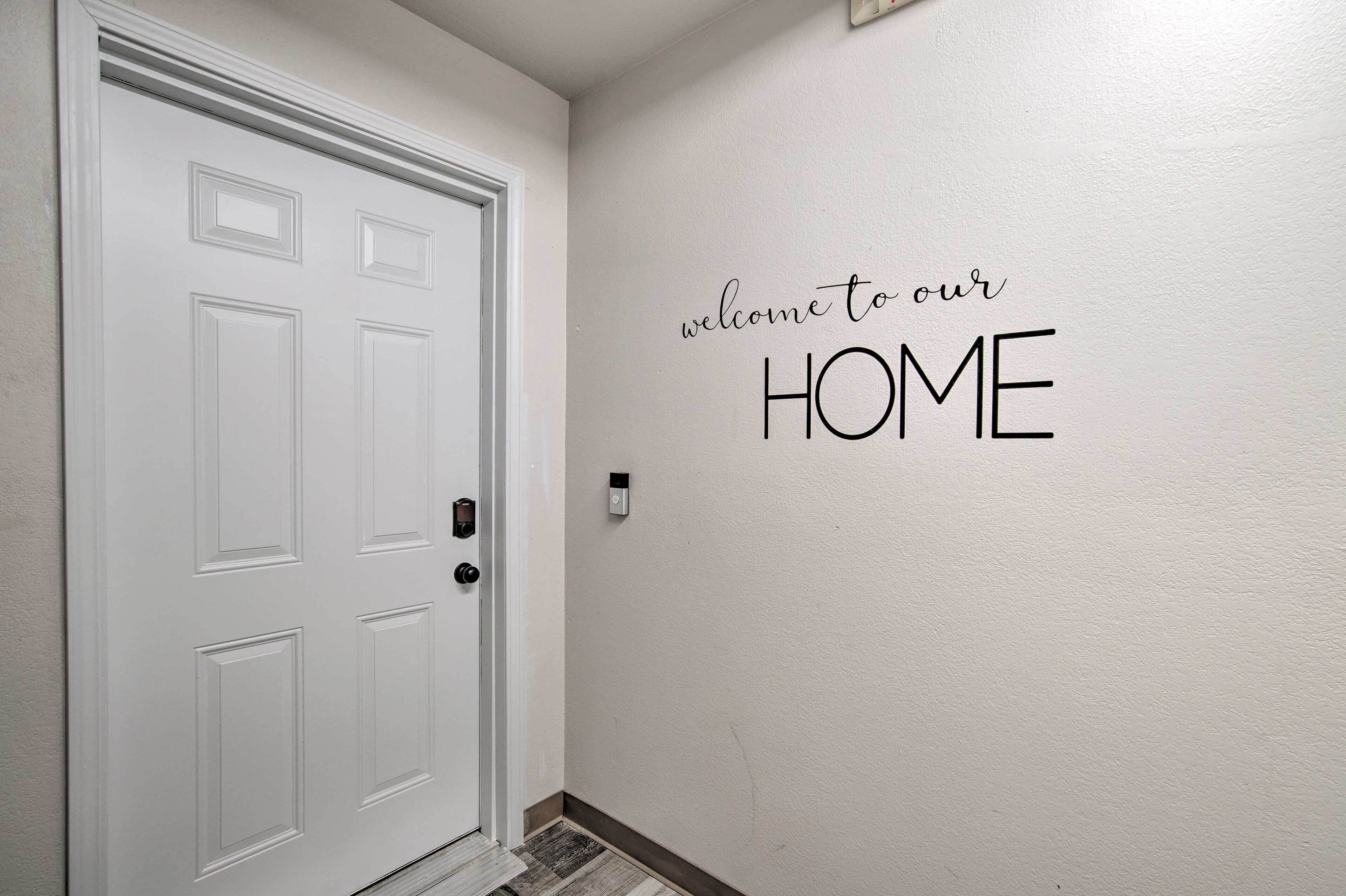 A white door with a modern handle and a wall-mounted intercom.