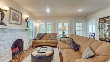 A living room with a fireplace, two sofas, a coffee table, and artwork on the walls.