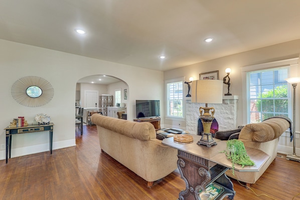 A spacious living room with a sofa, coffee table, and a television. - Walk to Amphitheater, Bjcc & Stadium: 1920s Gem! (Birmingham)