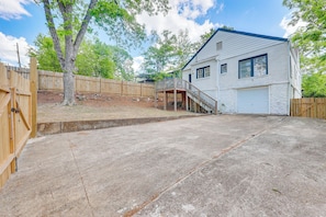 A residential house with a covered patio, a garage, and a wooden fence. - Walk to Amphitheater, Bjcc & Stadium: 1920s Gem! (Birmingham)