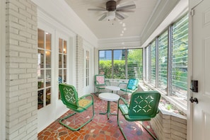 A covered patio with green chairs, a table, and a ceiling fan. - Walk to Amphitheater, Bjcc & Stadium: 1920s Gem! (Birmingham)