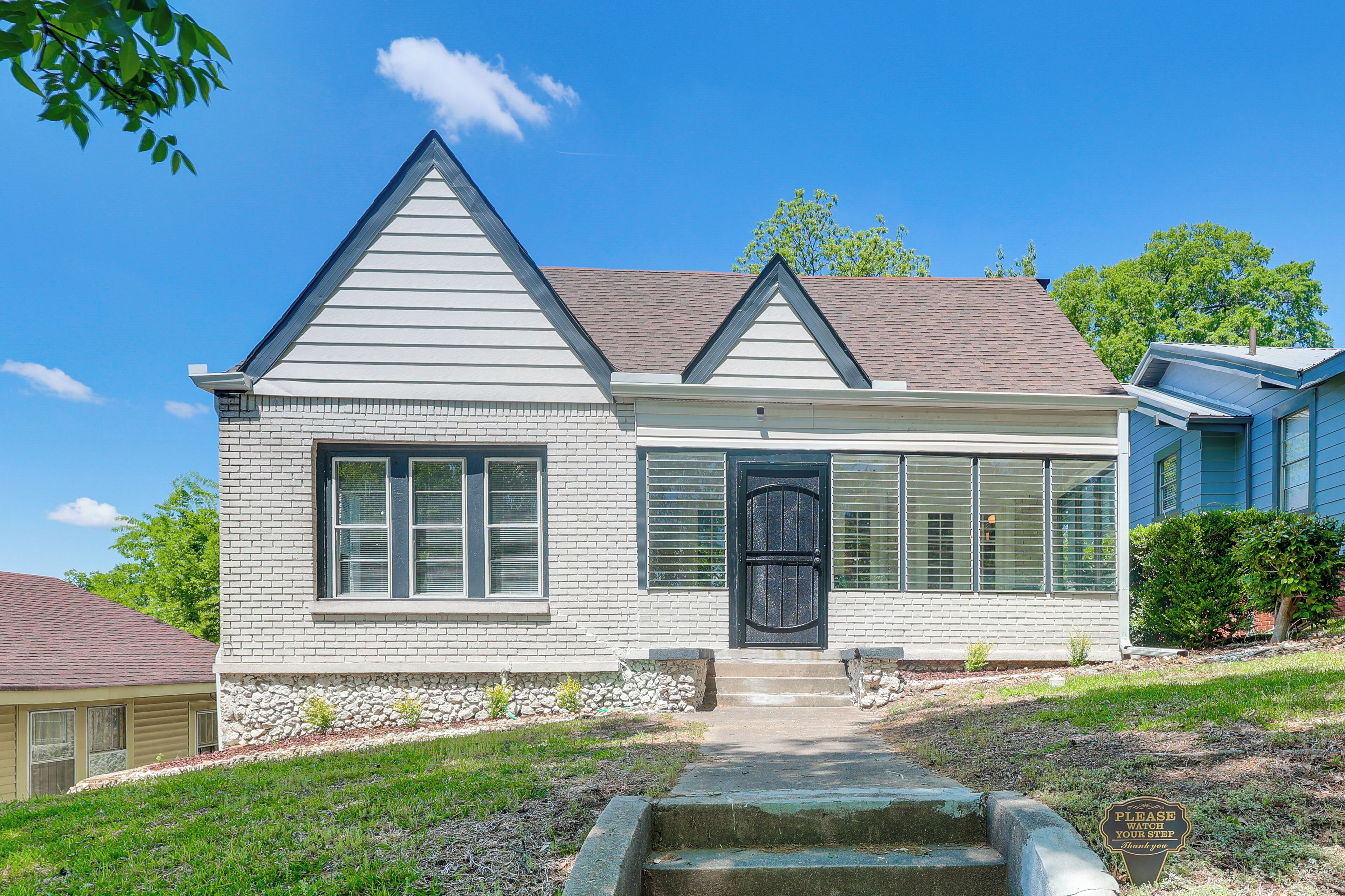 A single-story house with a gabled roof, a front door, and a small front yard.