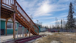 A residential property with a wooden staircase leading to a deck, a covered patio, and a fenced yard. - Alaskan Adventure Base 2 Mi to Dtwn Wasilla (Wasilla)