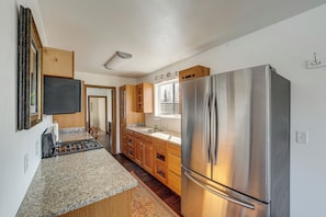 A kitchen with granite countertops, stainless steel appliances, wooden cabinets, and a window with a view. - Alaskan Adventure Base 2 Mi to Dtwn Wasilla (Wasilla)
