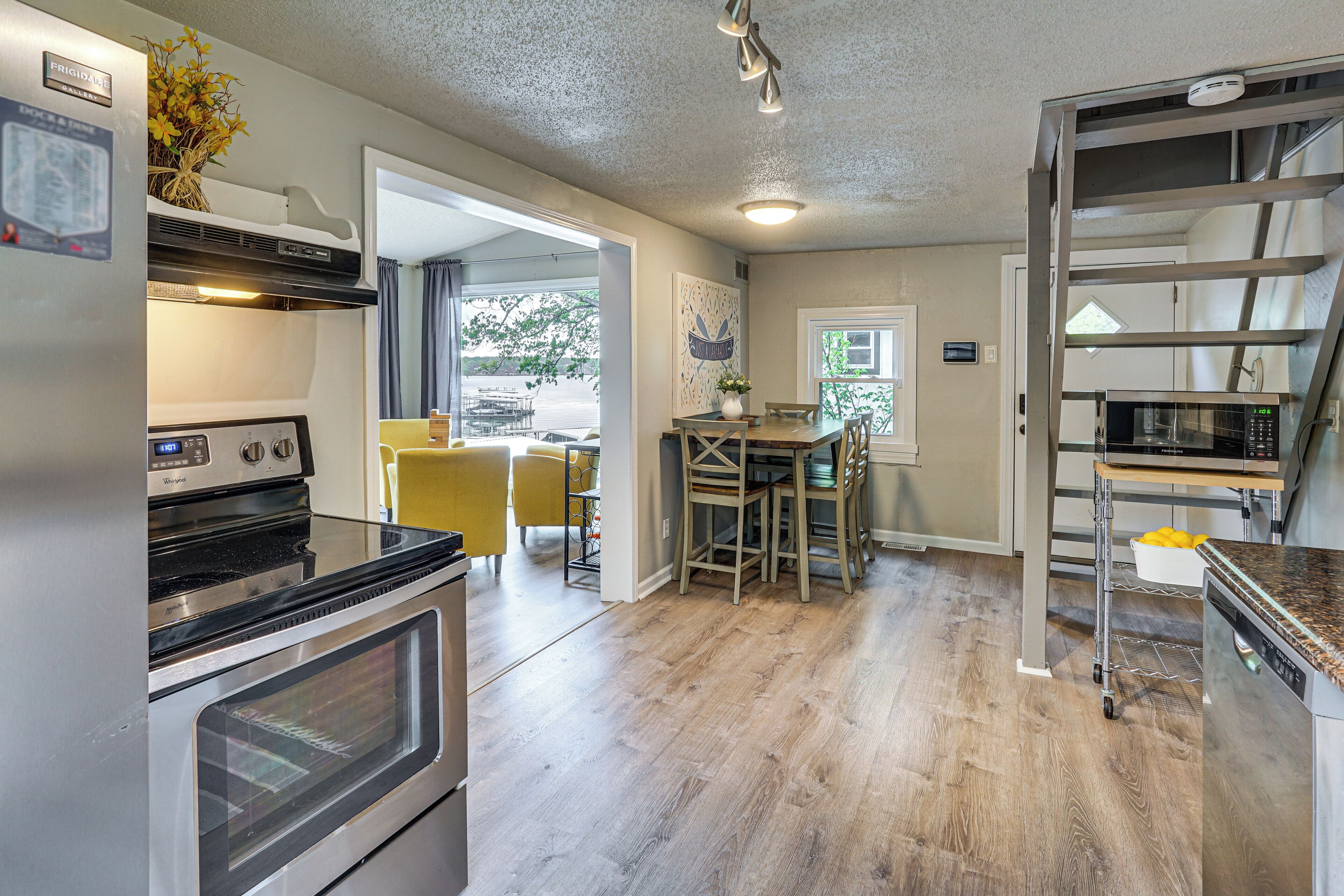 A kitchen with an oven, microwave, and a dining area with chairs and a table.
