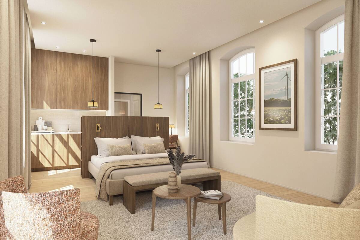 Une chambre d’hôtel moderne, équipée d’un lit, d’un coin salon, d’une petite table et offrant une vue sur l’extérieur.