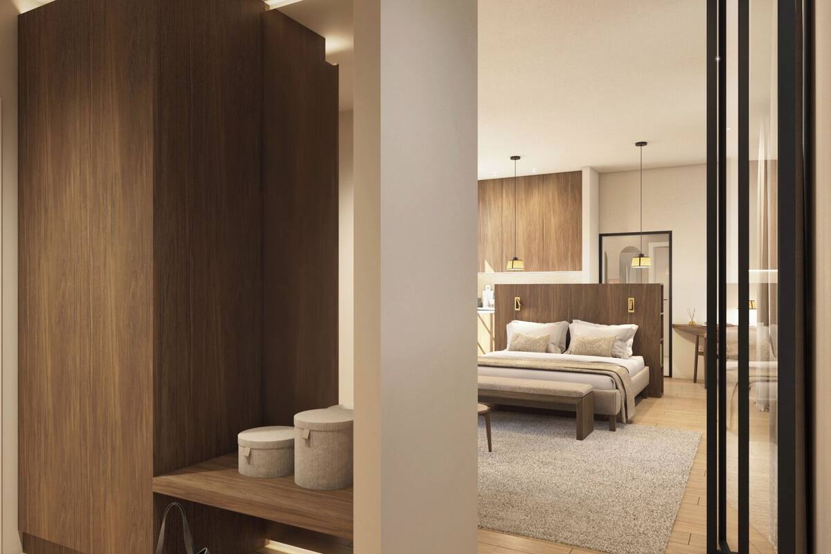 Une chambre à coucher moderne avec un grand lit, des tables de chevet et une armoire.