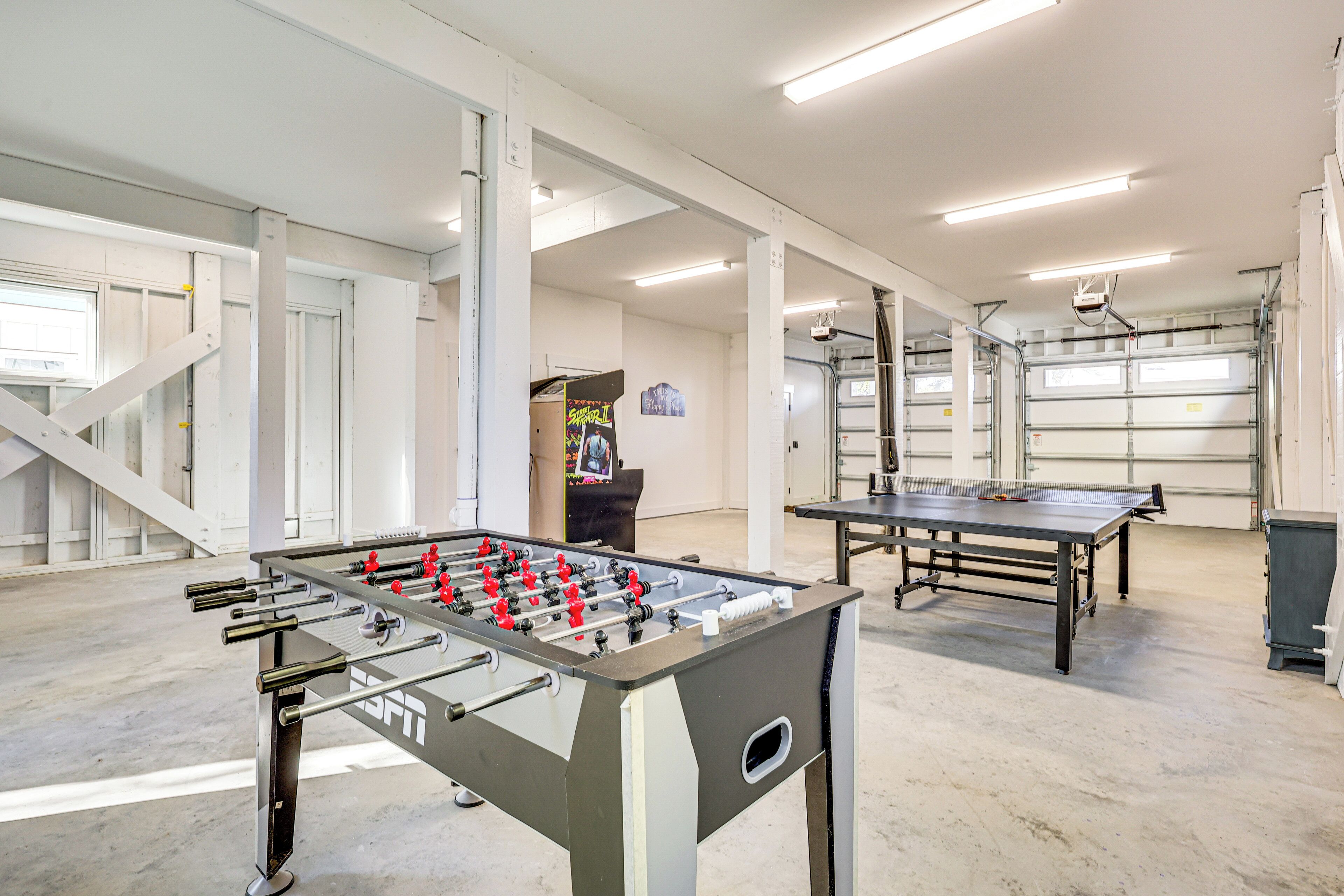A spacious indoor area with a foosball table and a ping pong table.