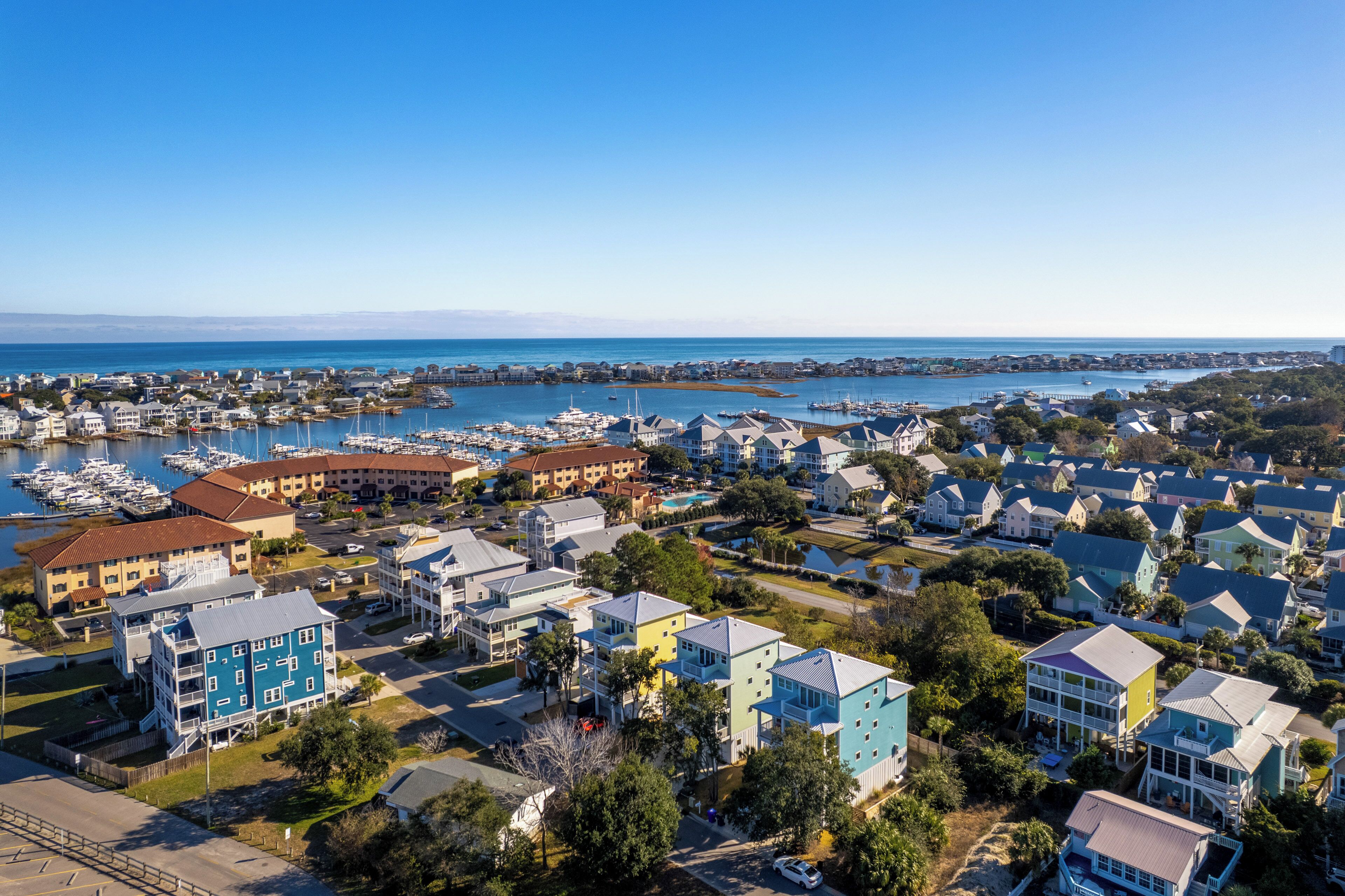 Un quartier résidentiel situé sur la côte, avec des maisons, un port de plaisance et des bateaux.