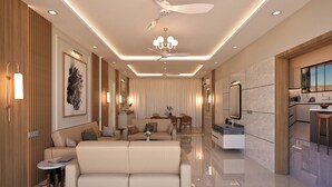 A modern living room with a sofa, a coffee table, and a dining area with chairs.
