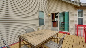 A wooden deck with a table and chairs, a sliding glass door, and a red railing. - 4 Mi to Ha Ha Tonka State Park! Home w/ Deck (Camdenton)
