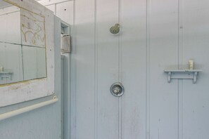 Ein Badezimmer mit Dusche, Toilette, Waschbecken und Spiegel.