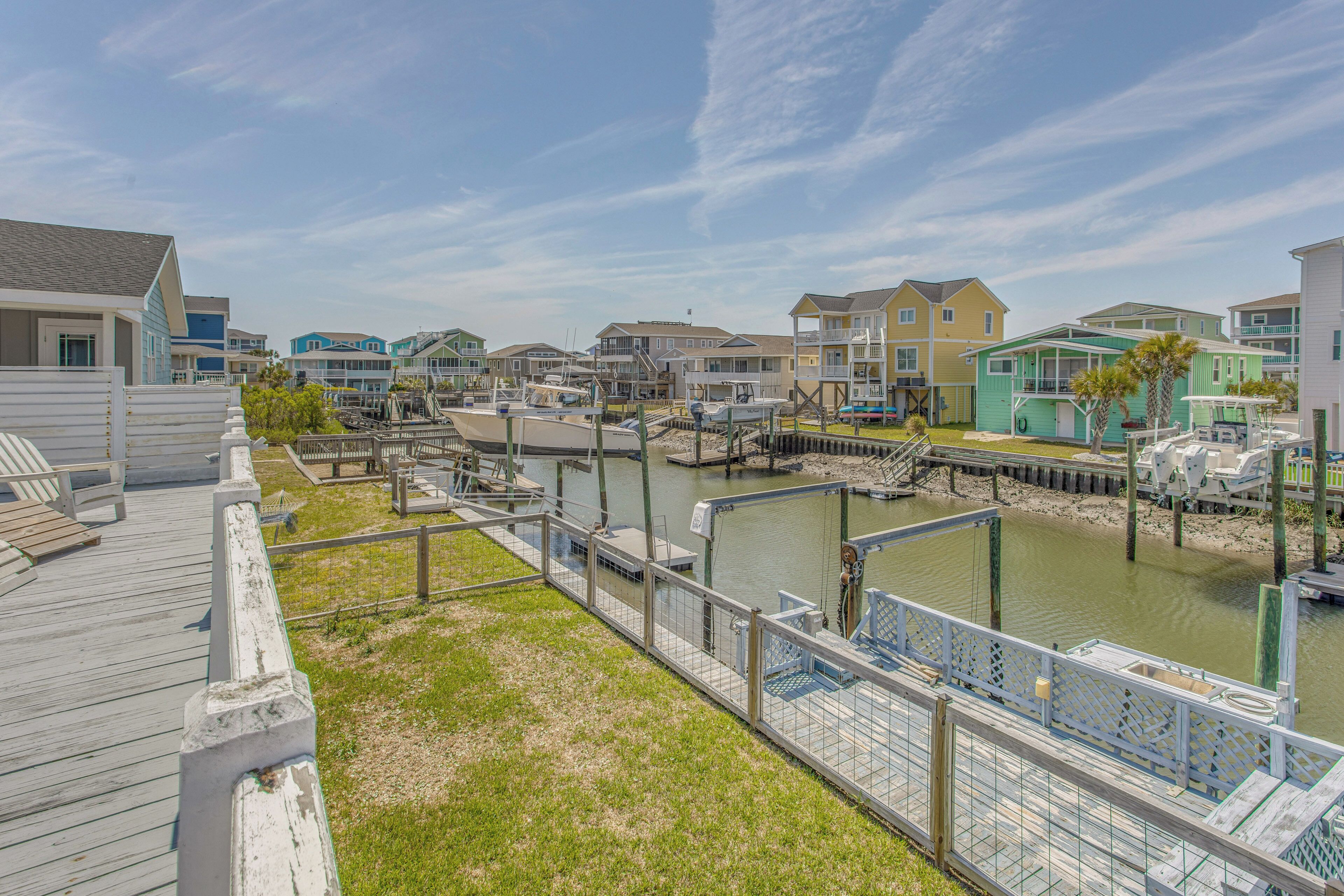 A waterfront residential area with houses, a dock, and a wooden walkway.