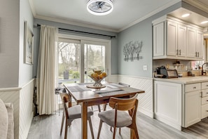 A dining area with a table, chairs, and a window with curtains. - Backyard Oasis w/ Hot Tub & Greenhouse! Toledo Gem (Toledo)