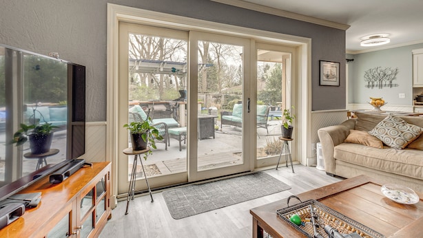 A living room with a TV, sofa, and sliding glass doors leading to an outdoor patio. - Backyard Oasis w/ Hot Tub & Greenhouse! Toledo Gem (Toledo)