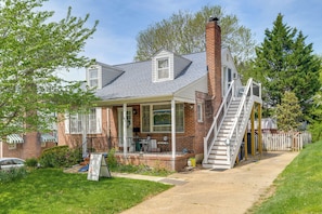 A two-story house with a brick exterior, a covered porch, and a staircase leading to the upper level. - Gateway to Downtown Baltimore! Cozy & Private Unit (Baltimore)