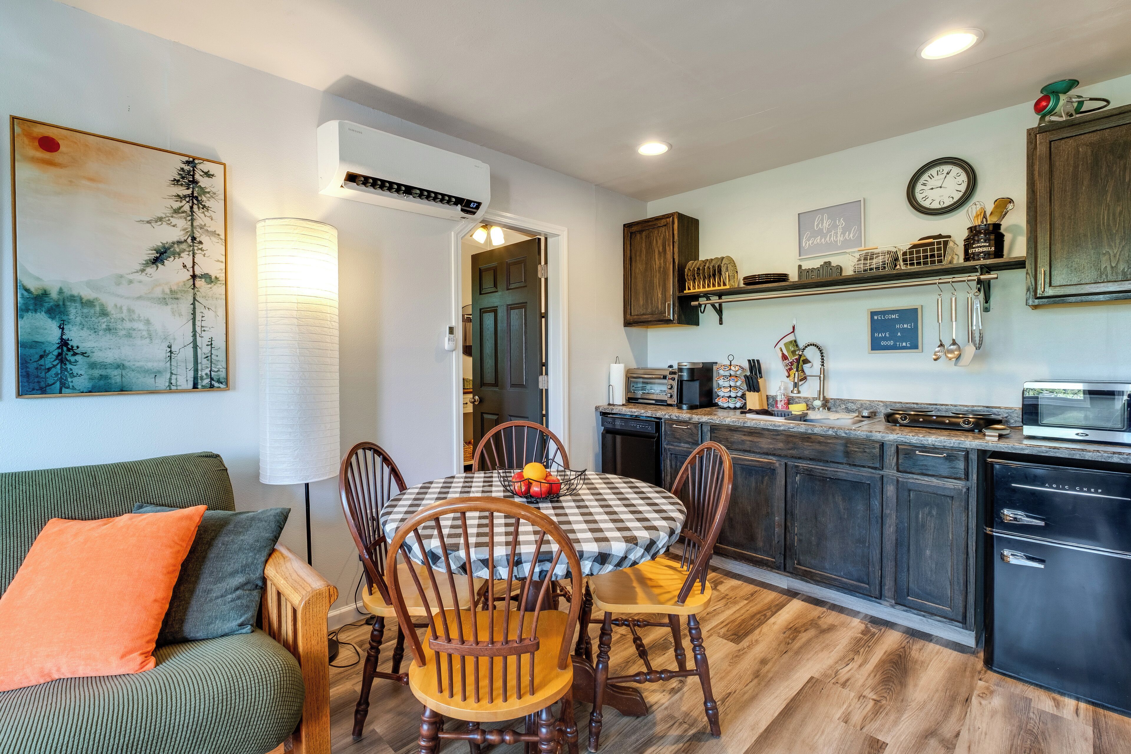 A modern kitchen with a dining table, chairs, and a built-in stove.