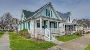 A two-story house with a porch, a front yard, and a sidewalk. - Explore Dtwn Sandusky! Unique Lake Erie Getaway (Sandusky)