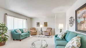 A living room with a sofa, two armchairs, a coffee table, a lamp, and a painting on the wall. - On Sun City South Golf Course! Quiet Home w/ Patio (Sun City)