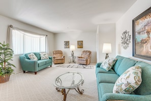 A living room with a sofa, two armchairs, a coffee table, a lamp, and a painting on the wall. - On Sun City South Golf Course! Quiet Home w/ Patio (Sun City)