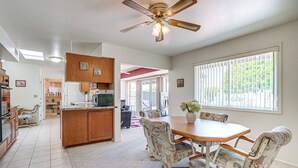 A spacious kitchen with a dining area, wooden cabinets, and a ceiling fan. - On Sun City South Golf Course! Quiet Home w/ Patio (Sun City)