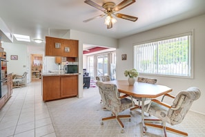 A spacious kitchen with a dining area, wooden cabinets, and a ceiling fan. - On Sun City South Golf Course! Quiet Home w/ Patio (Sun City)