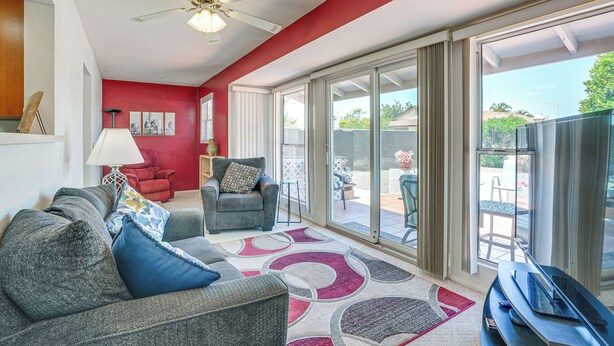 A living room with a sofa, armchair, and a TV stand. - On Sun City South Golf Course! Quiet Home w/ Patio (Sun City)