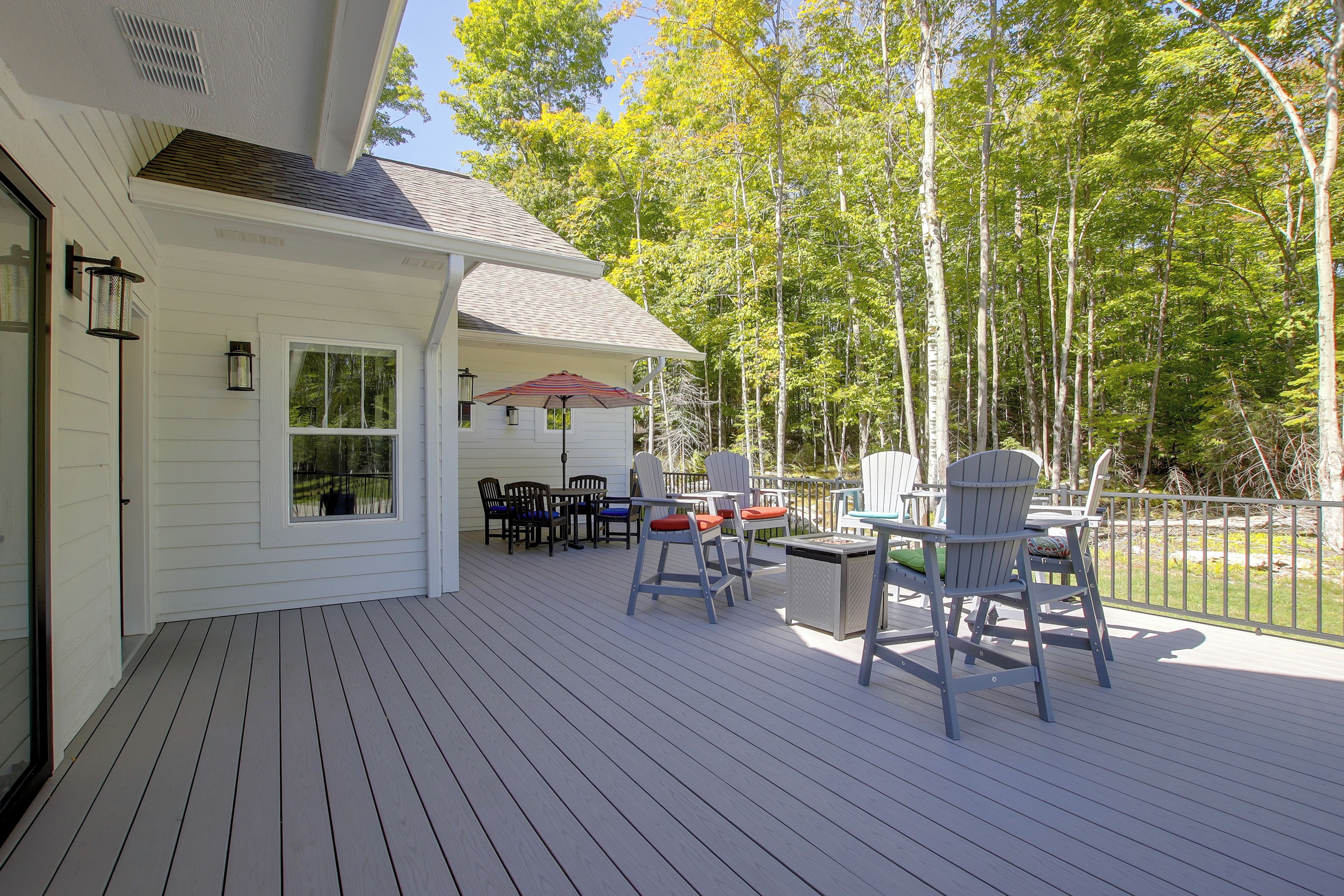 A covered deck with outdoor furniture, a table, and chairs.