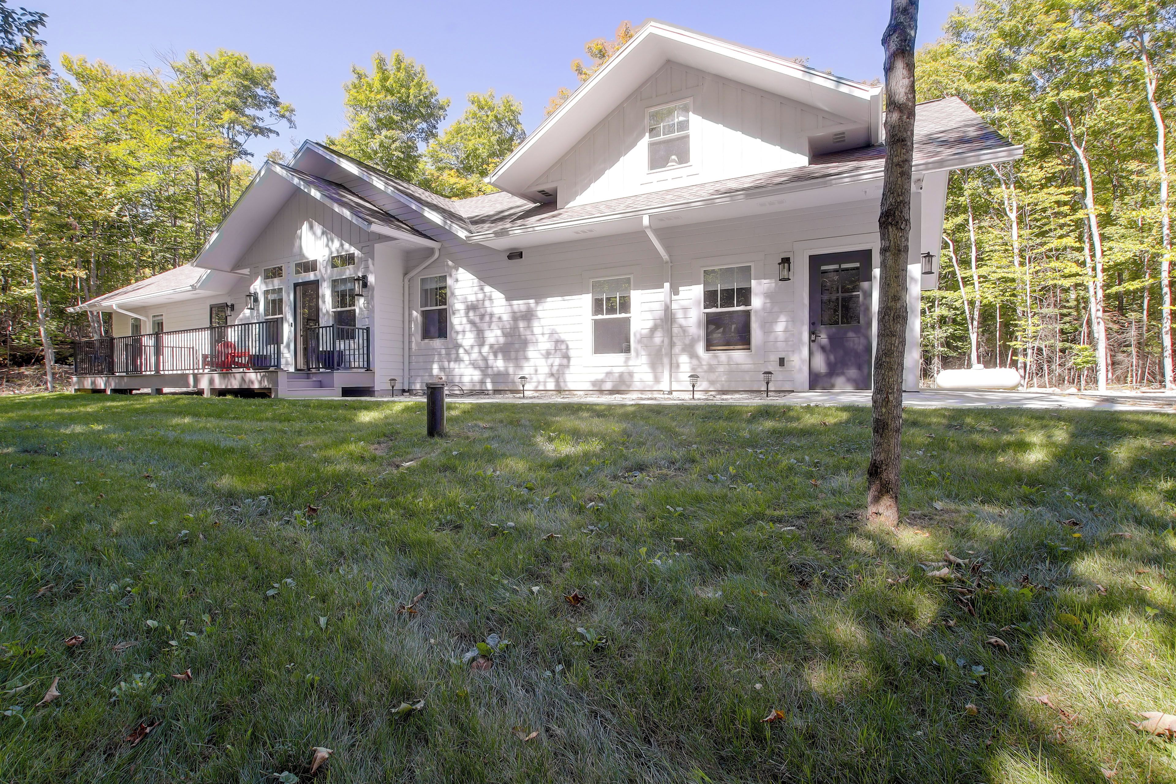 A two-story house with a covered porch and a fenced yard.