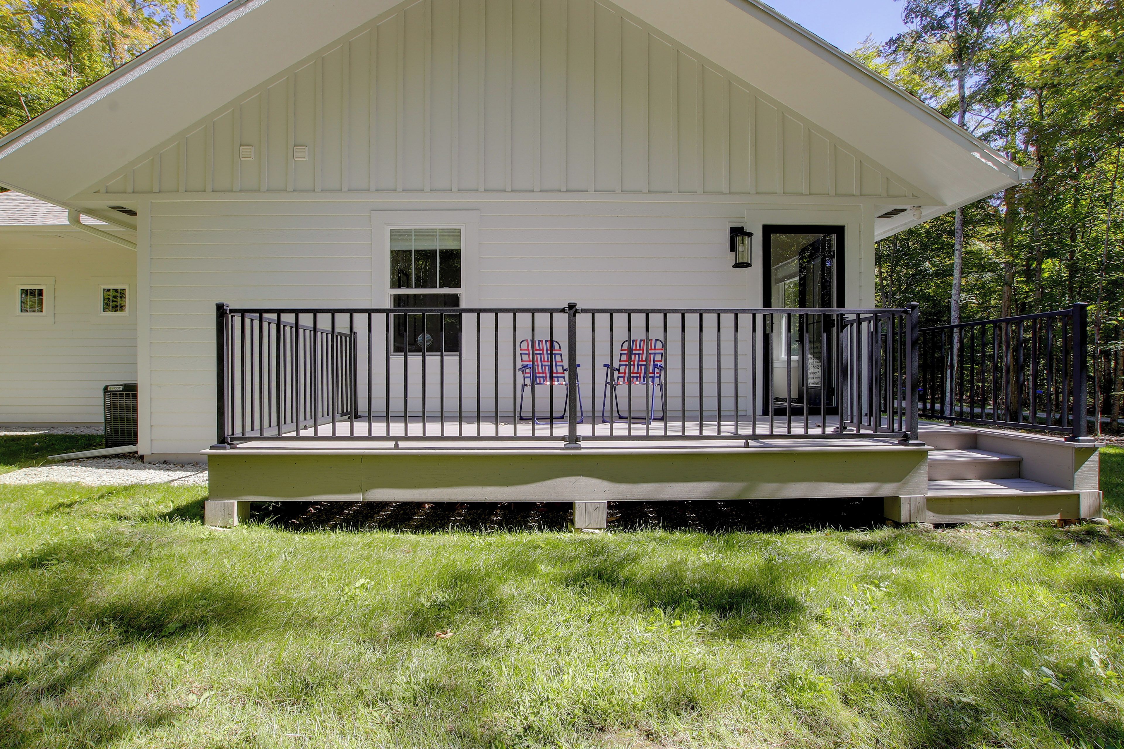 A white building with a porch and a black railing.