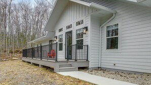 Ein Haus mit einer Veranda, einer Haustür und einer kleinen Treppe zum Eingang.