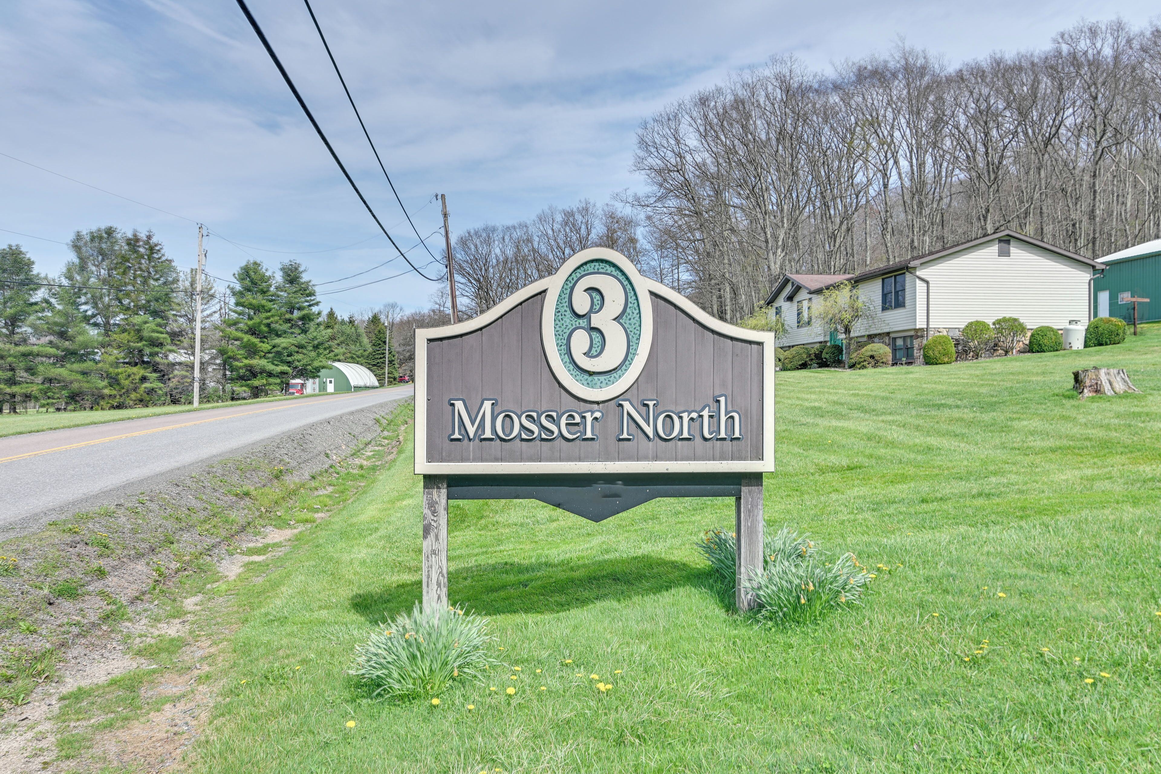 Un cartel que indica 'Mossor North' con una casa al fondo.