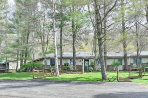 A motel with a simple, single-story structure, a front parking area, and a small front yard with a wooden fence.