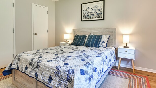 Una camera da letto con un letto, due comodini, un tavolino e un quadro appeso al muro.