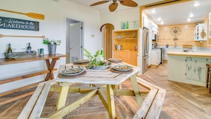 Eine rustikale Küche mit Holzschränken, einer Mittelinsel und einem Deckenventilator.