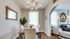 A dining area with a wooden table, chairs, a chandelier, and a potted plant. - Private Deck & Yard: Pet-friendly Noble Getaway (Noble)
