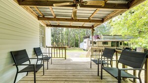 A covered outdoor deck with wooden flooring and metal-framed chairs. - Private Deck & Yard: Pet-friendly Noble Getaway (Noble)
