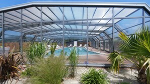 Uma estufa com piscina, cercada por diversas plantas.