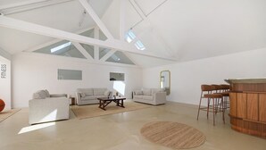 Ampla sala de estar com pé direito alto, janelas grandes e design minimalista.