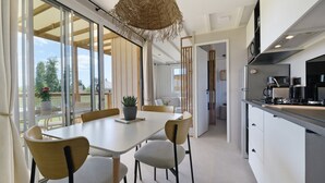 Cozinha moderna com área de refeições, janelas amplas e vista para o exterior.